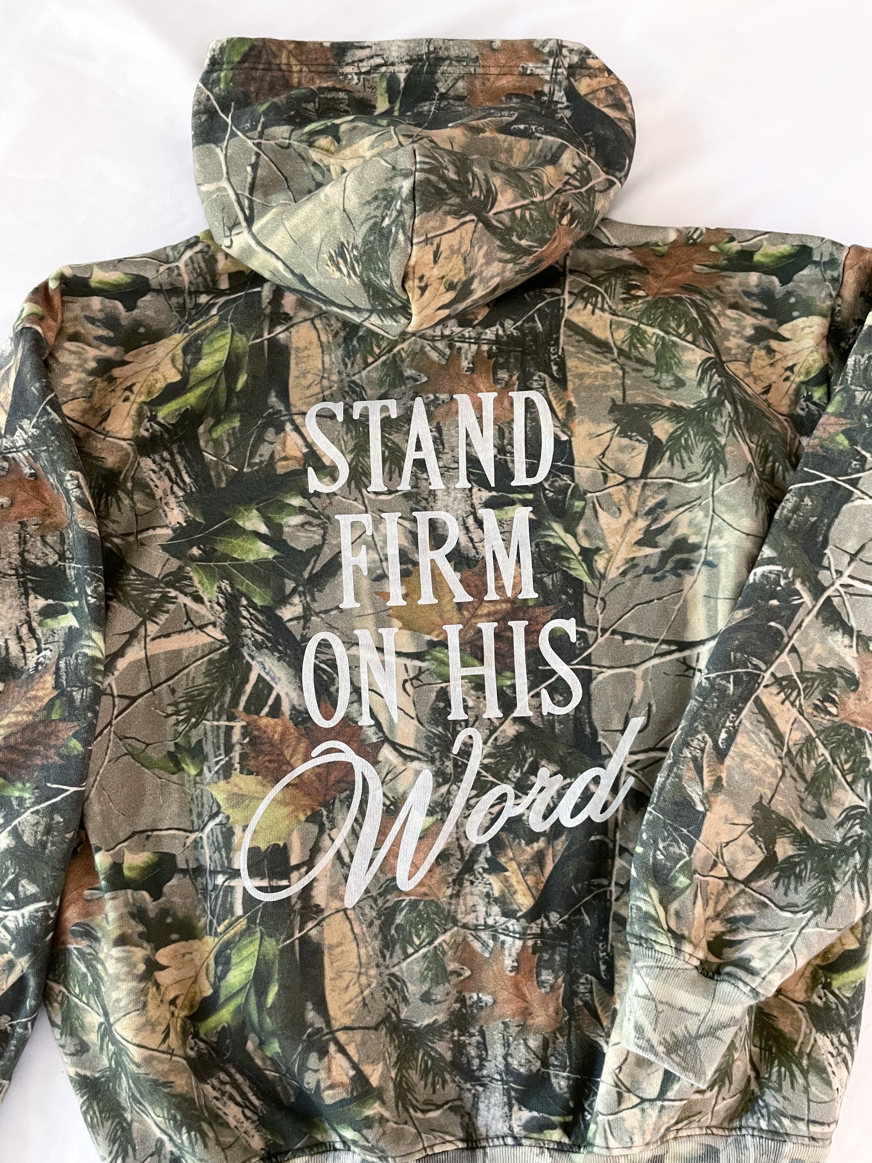 a camo hoodie with the words stand firm on his hood