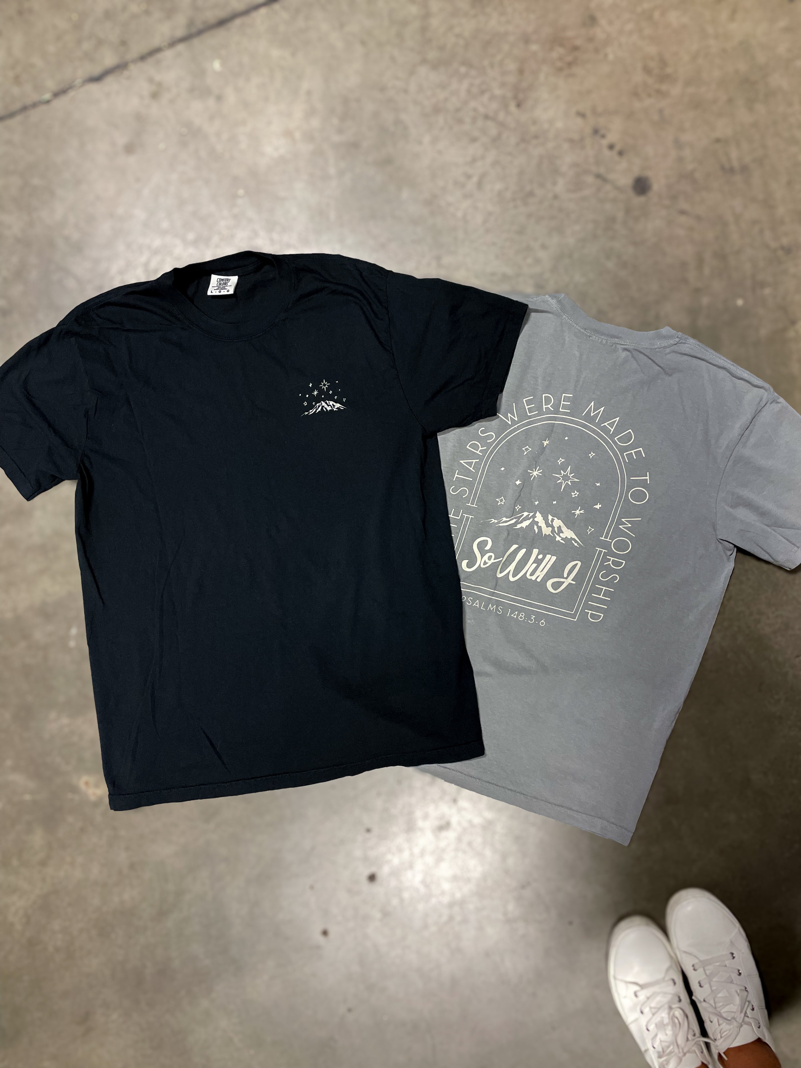 two t - shirts sitting next to each other on a floor