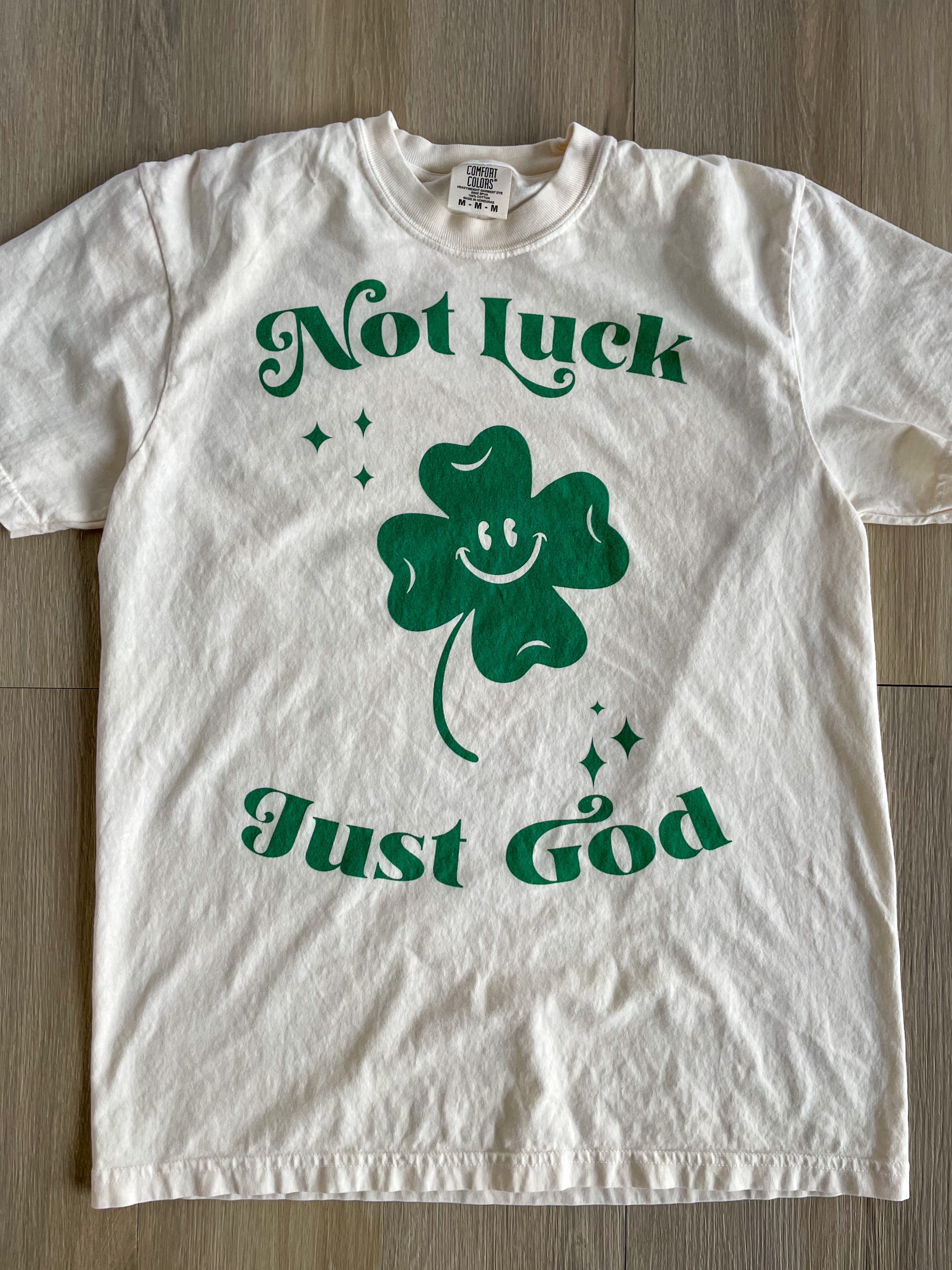 a white t - shirt with a green shamrock on it