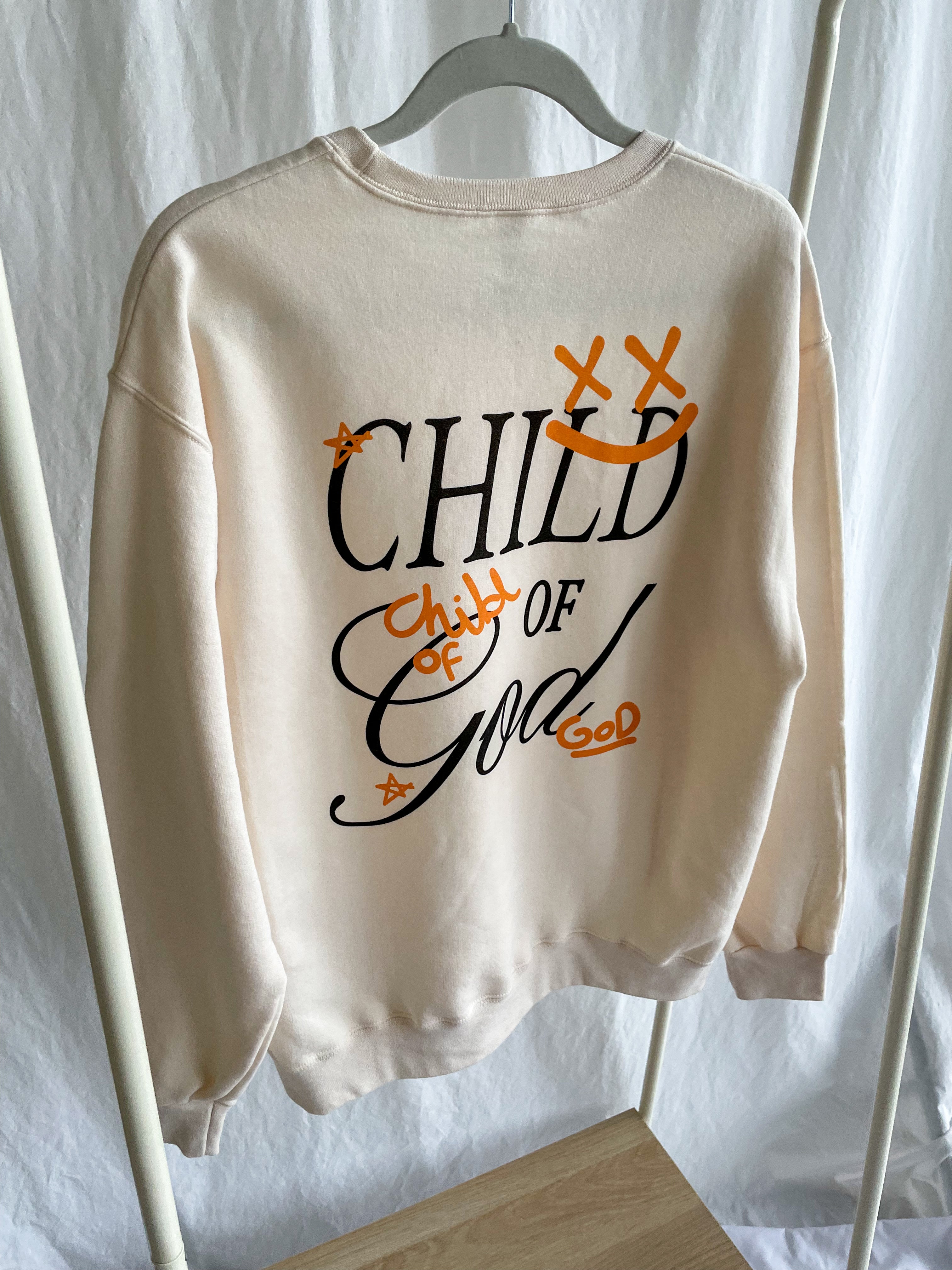a white sweatshirt with the words child of god printed on it