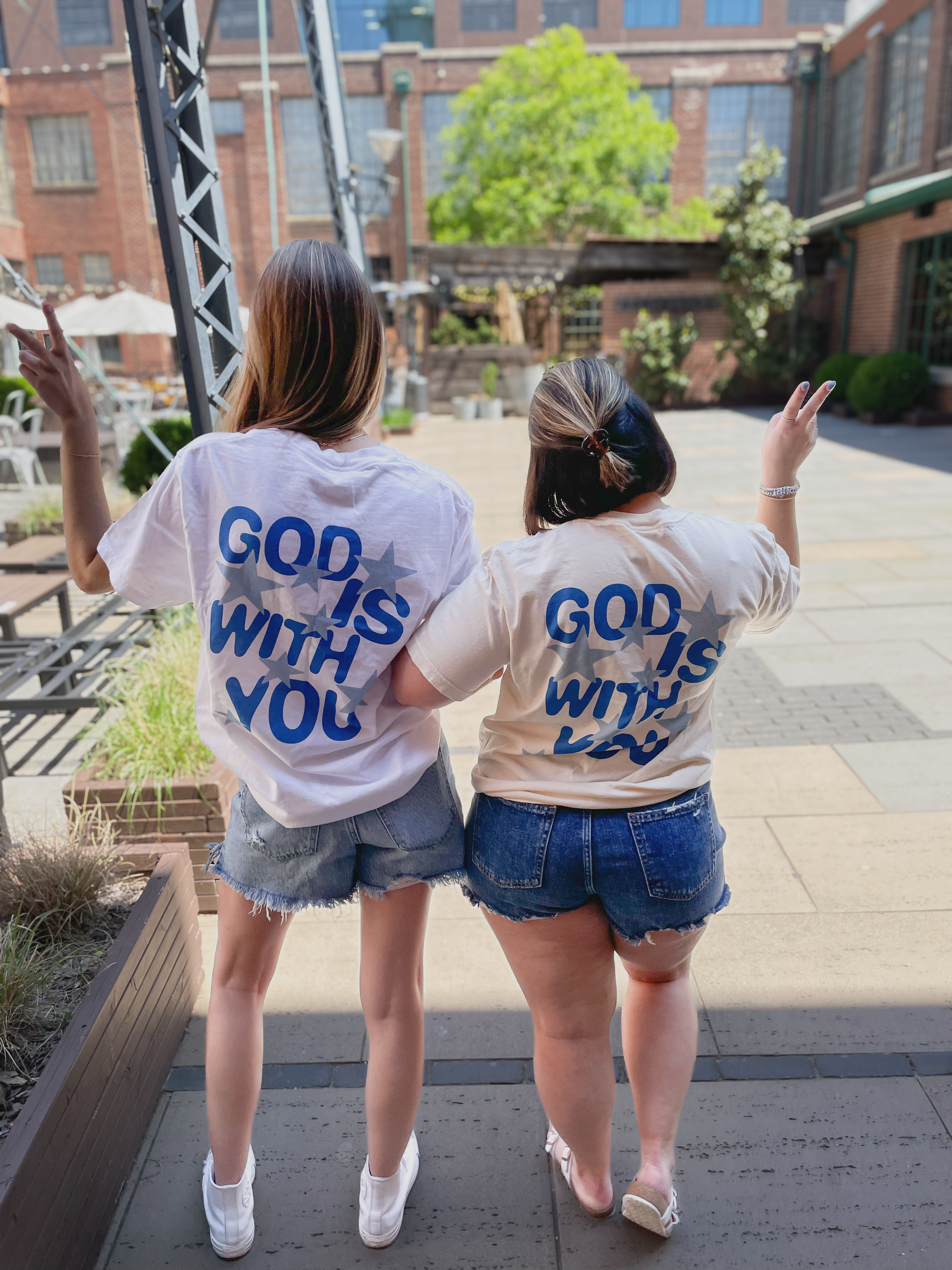 two girls wearing t - shirts that say god is with you