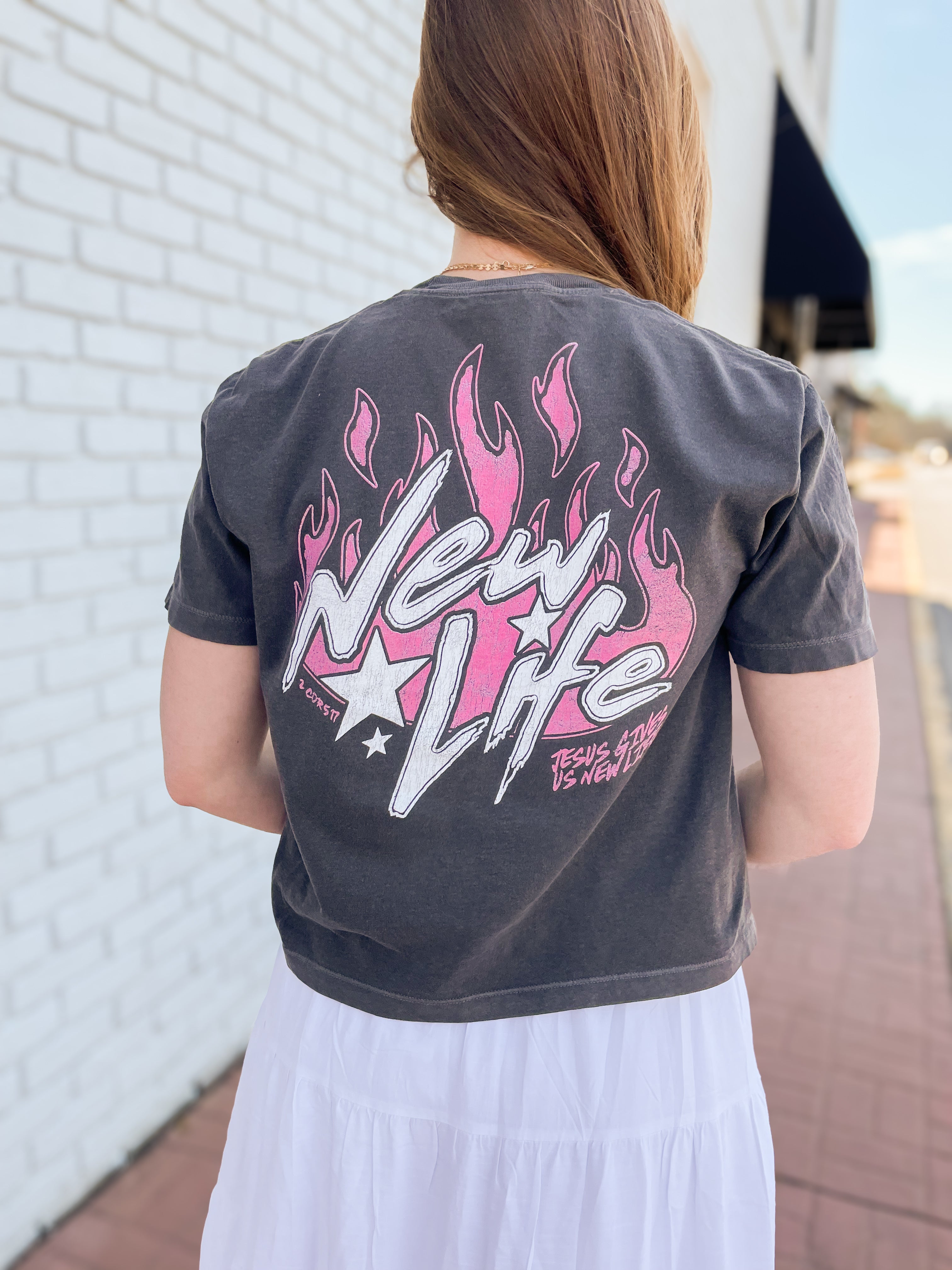 a woman wearing a black shirt with pink flames on it