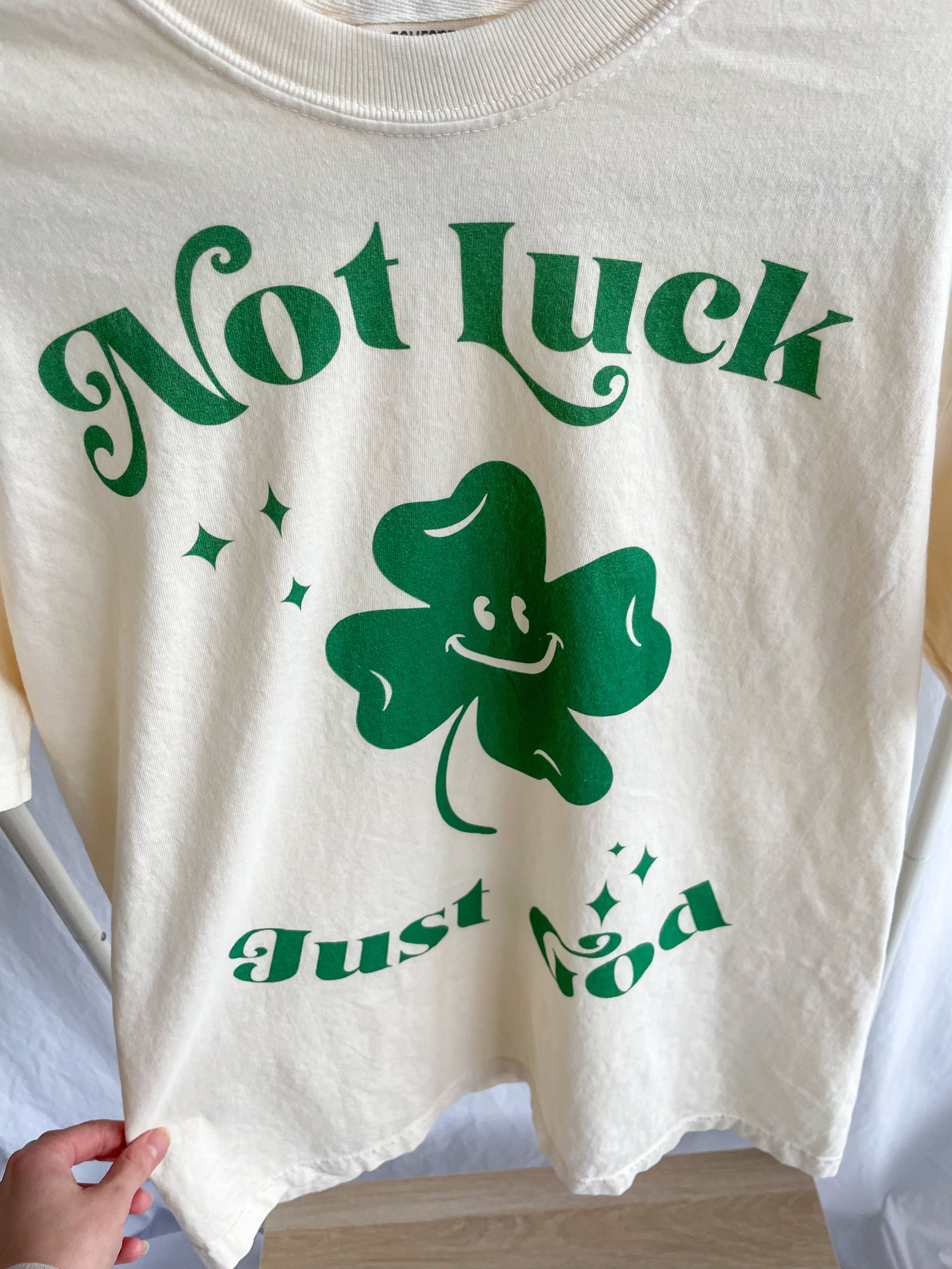 a white t - shirt with a green shamrock on it