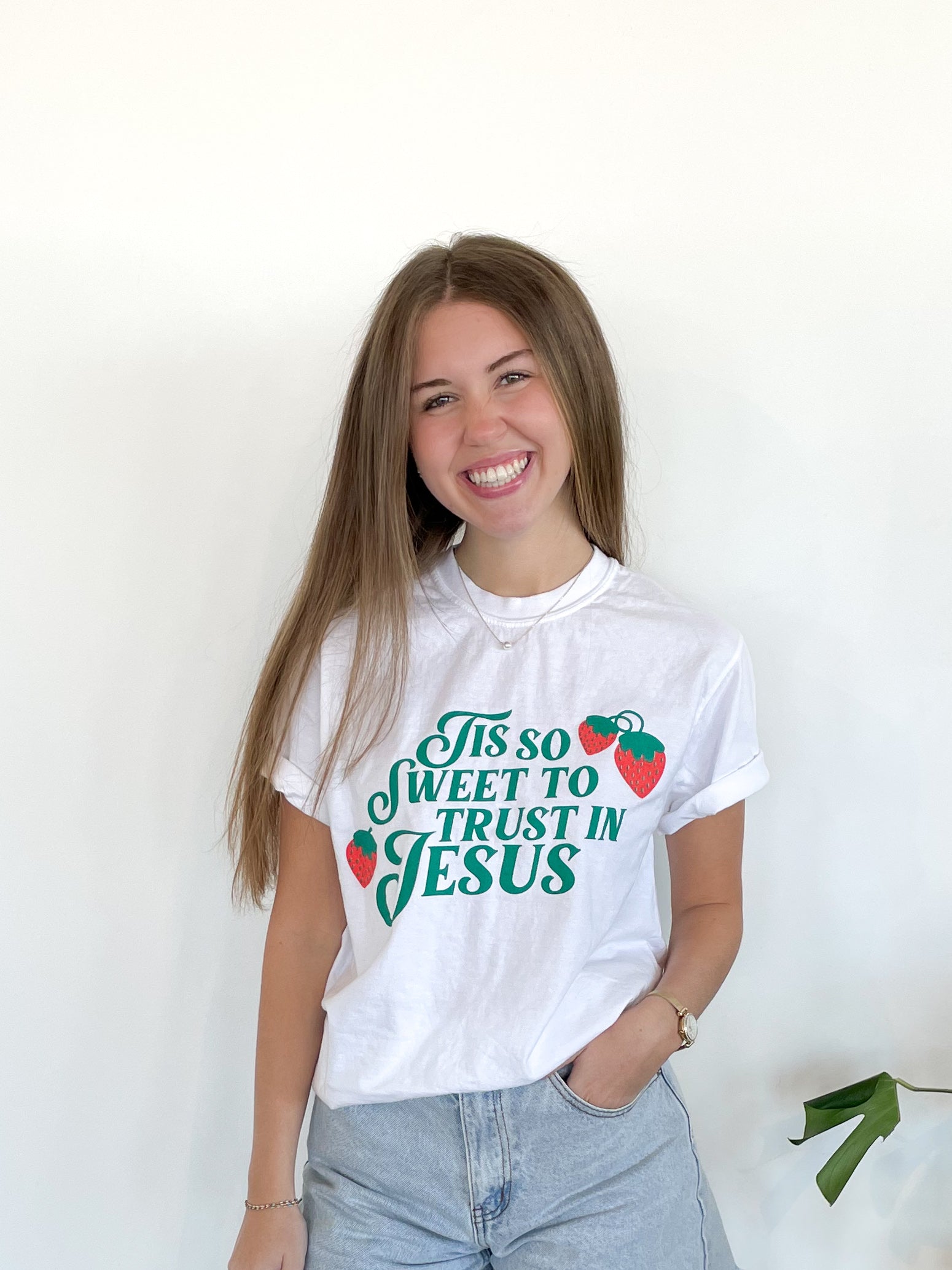 a woman wearing a white shirt with the words yes so sweet to trust in jesus