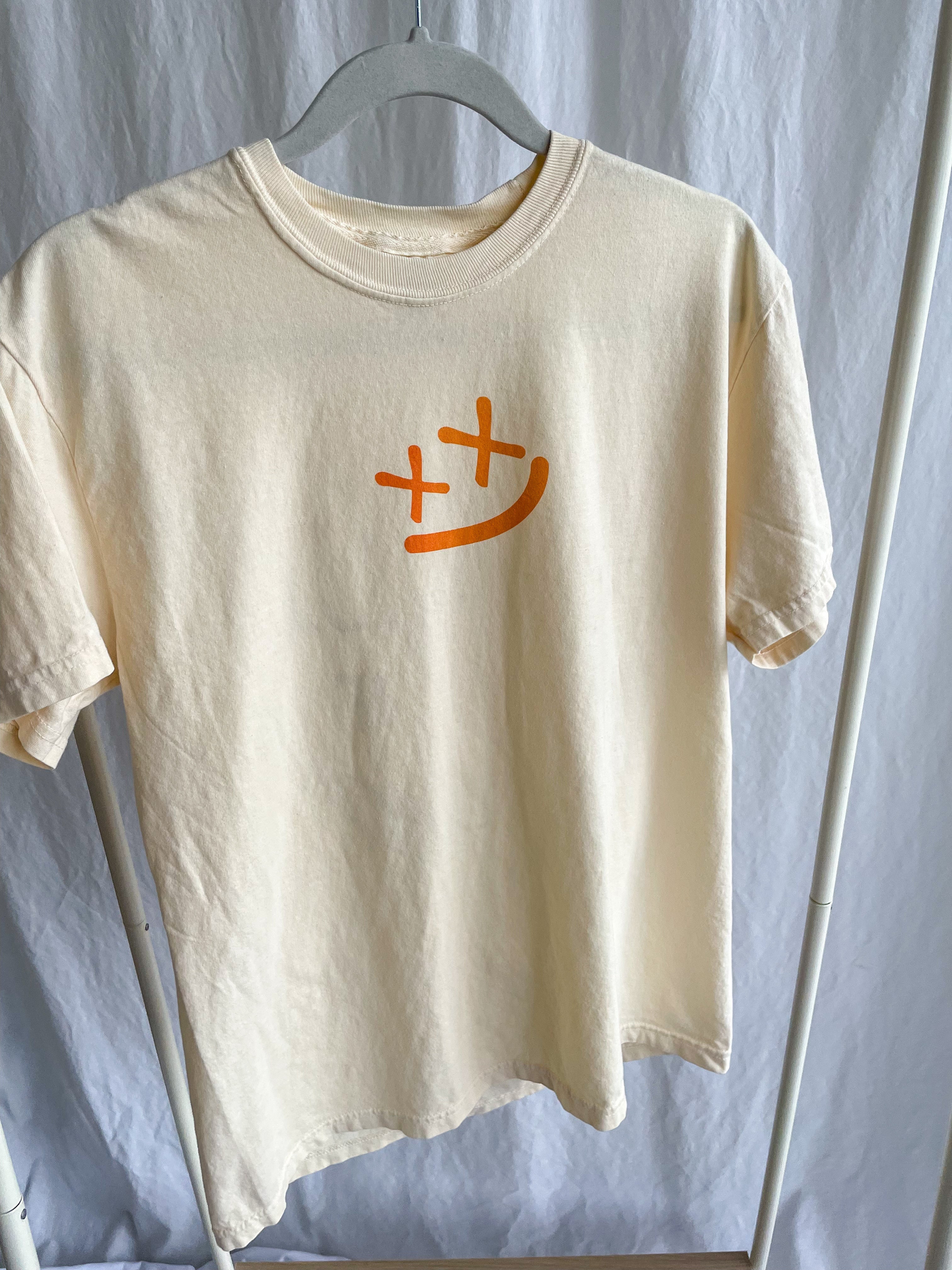 a white t - shirt with an orange cross on it