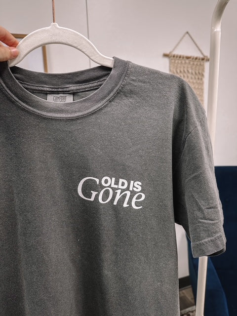 a person holding a t - shirt with the words cold is gone on it