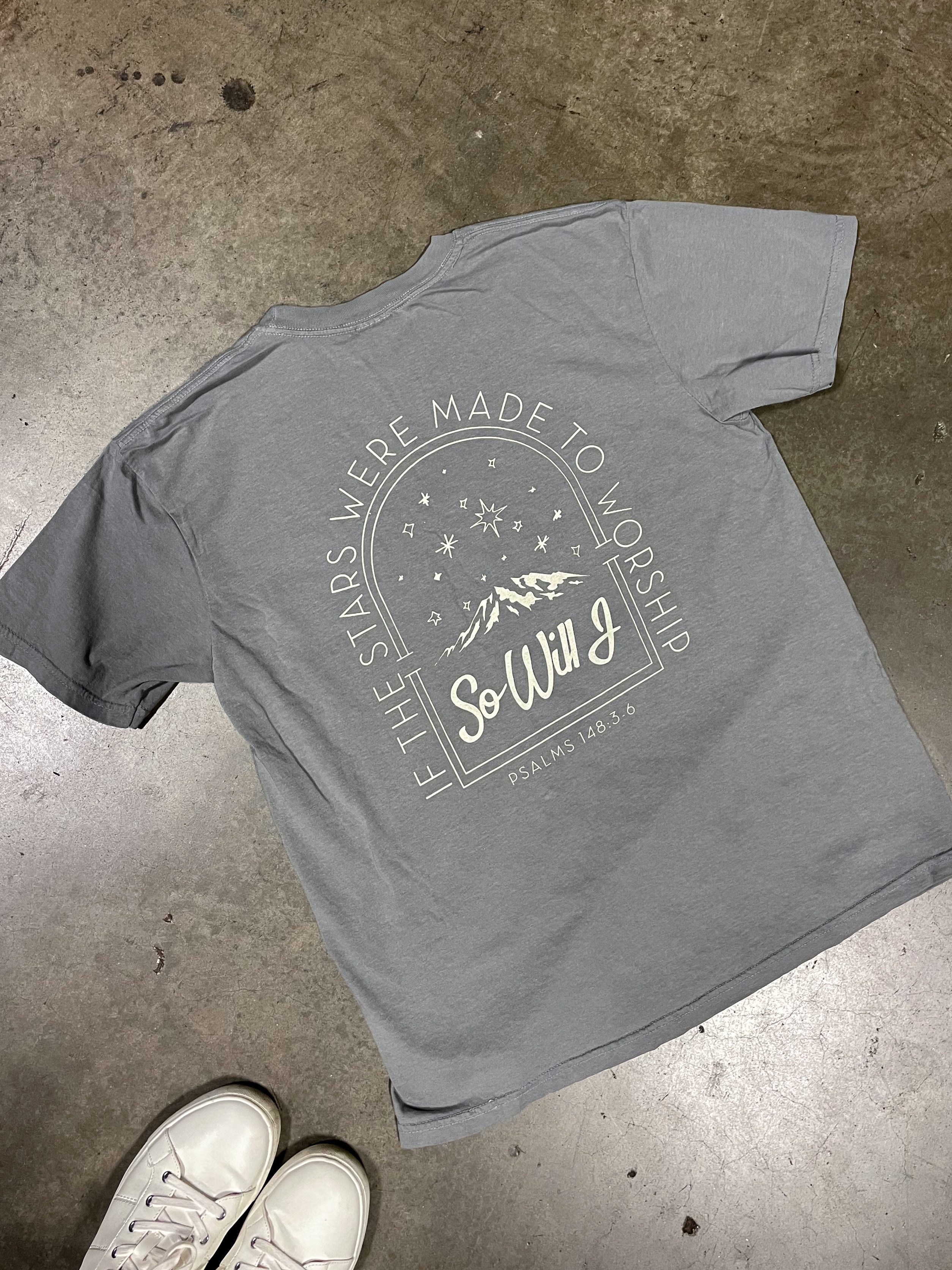 a pair of white shoes and a gray t - shirt