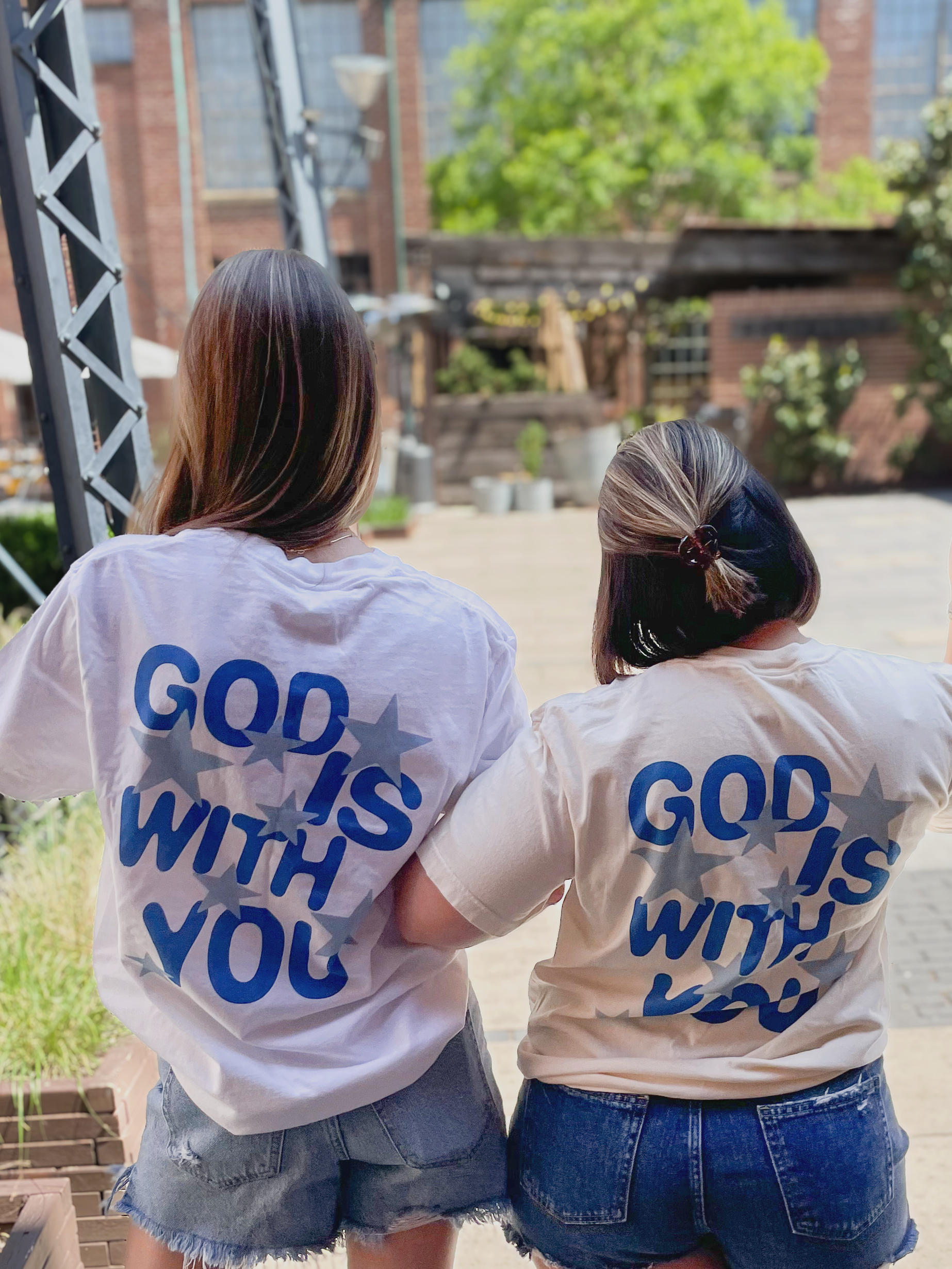 two girls wearing t - shirts that say god is with you