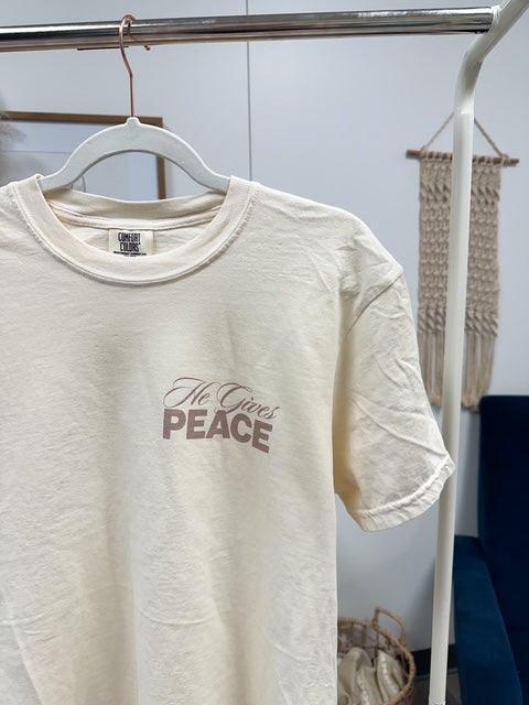 a t - shirt that says peace hanging on a rack