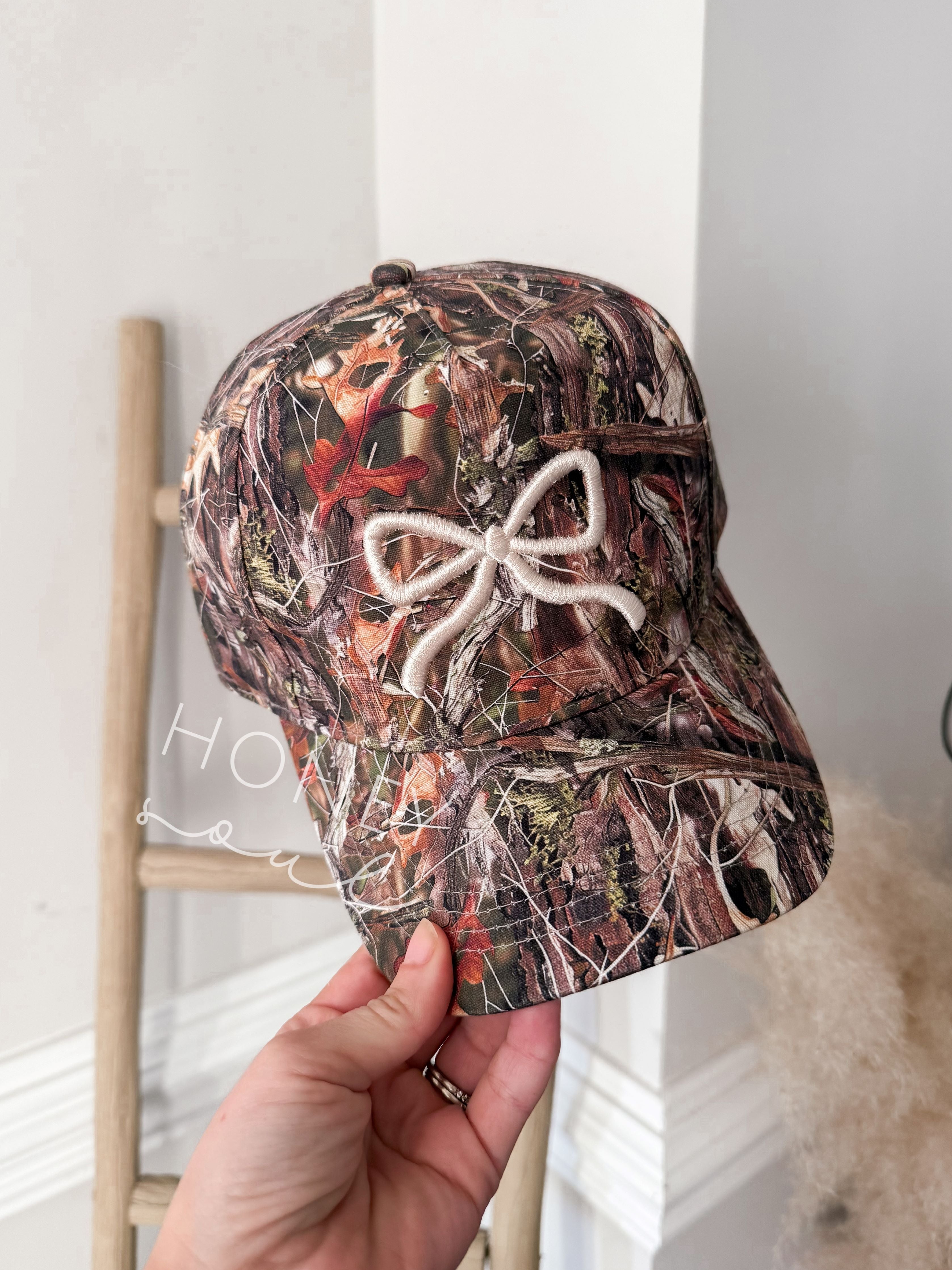 a person holding up a hat with a bow on it