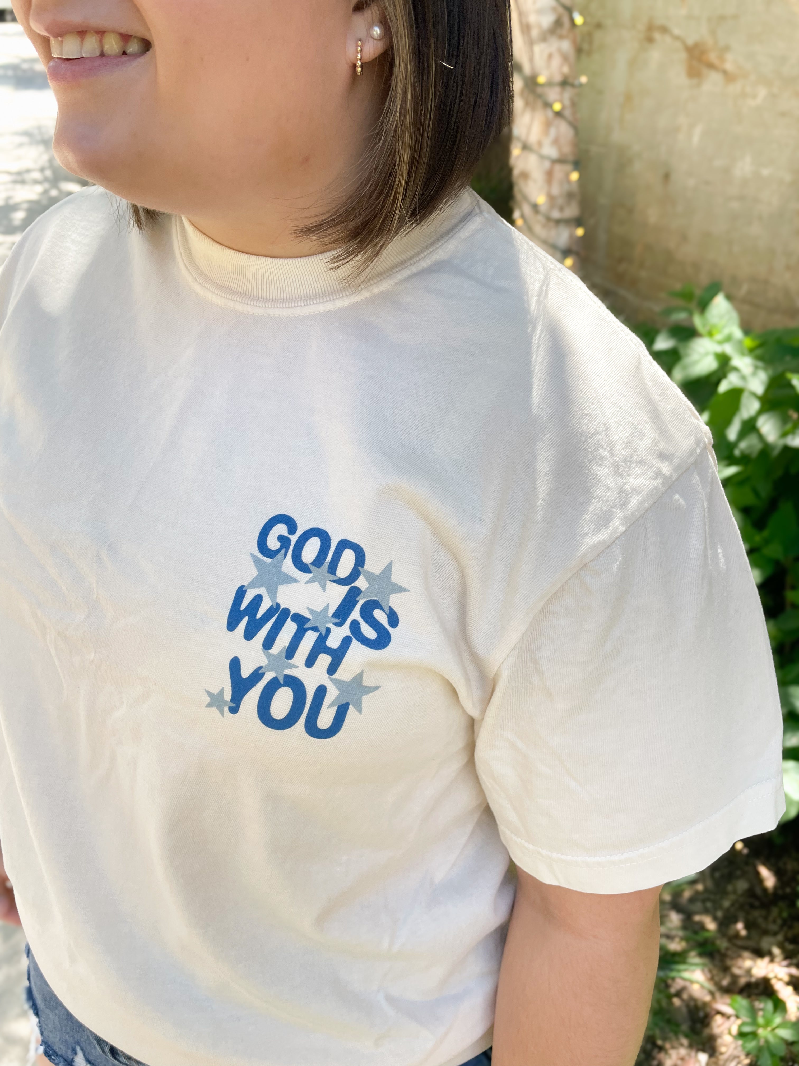a woman wearing a t - shirt that says god is with you