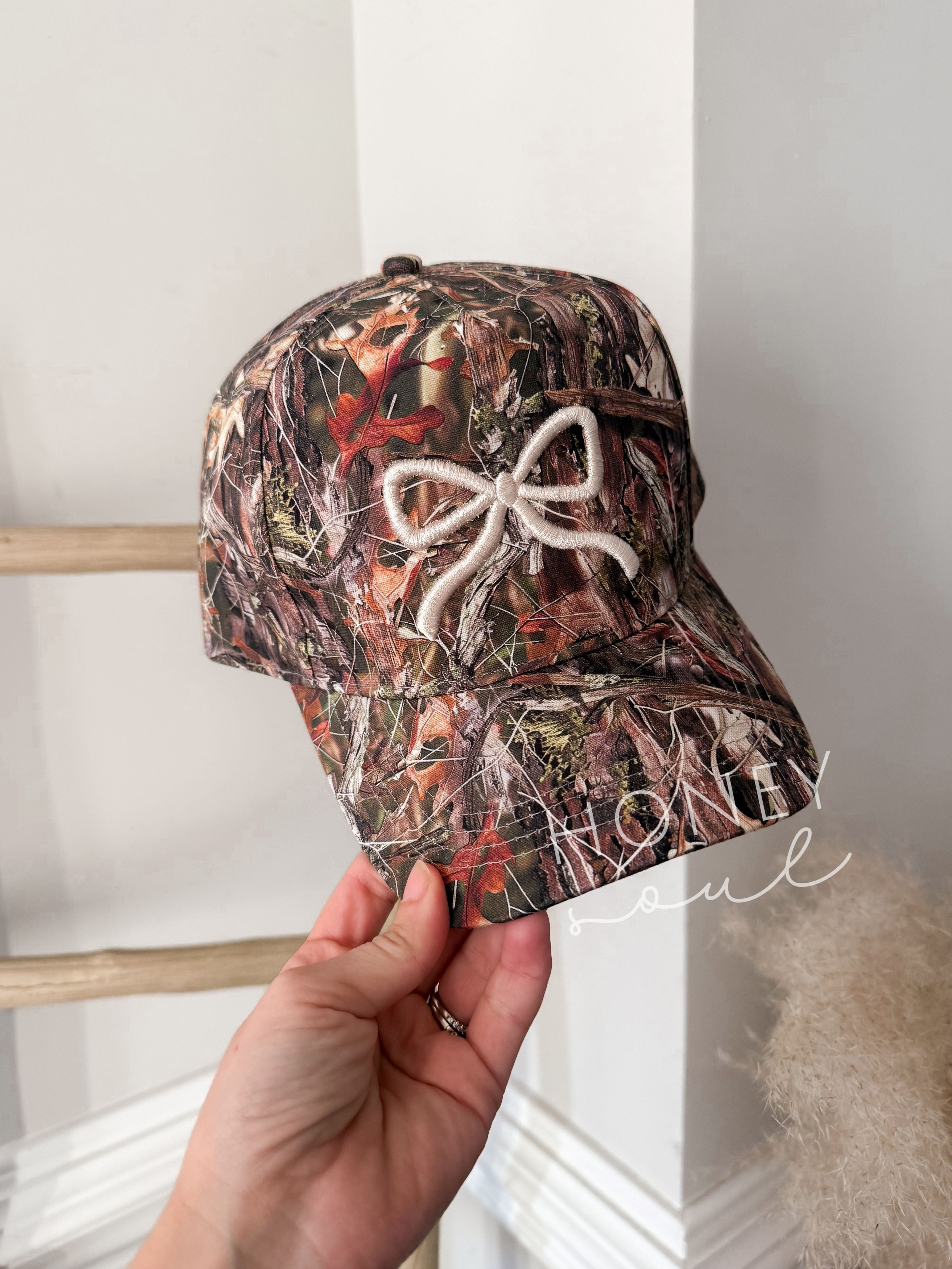 a person holding up a hat with a bow on it