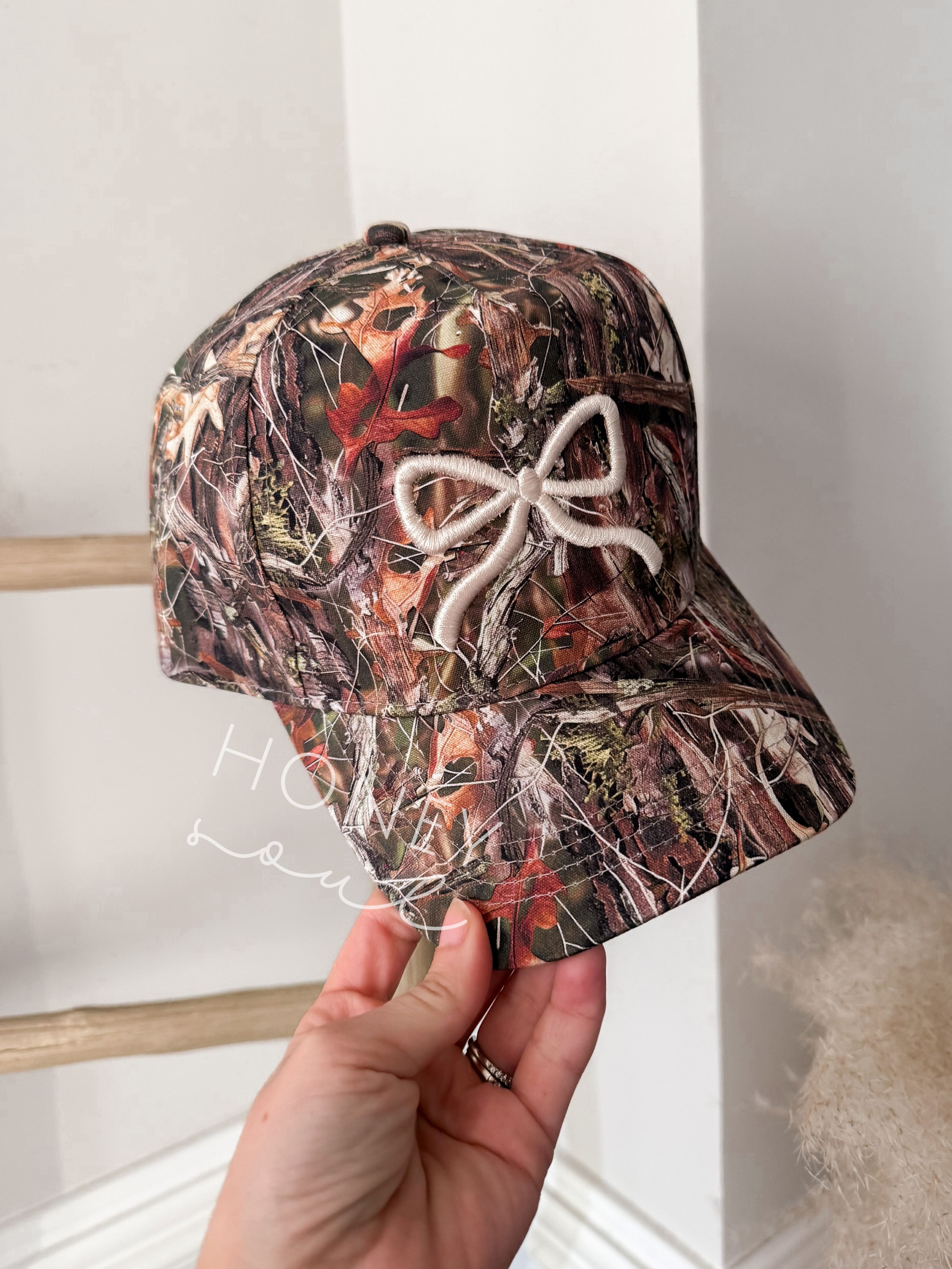 a person holding up a hat with a bow on it