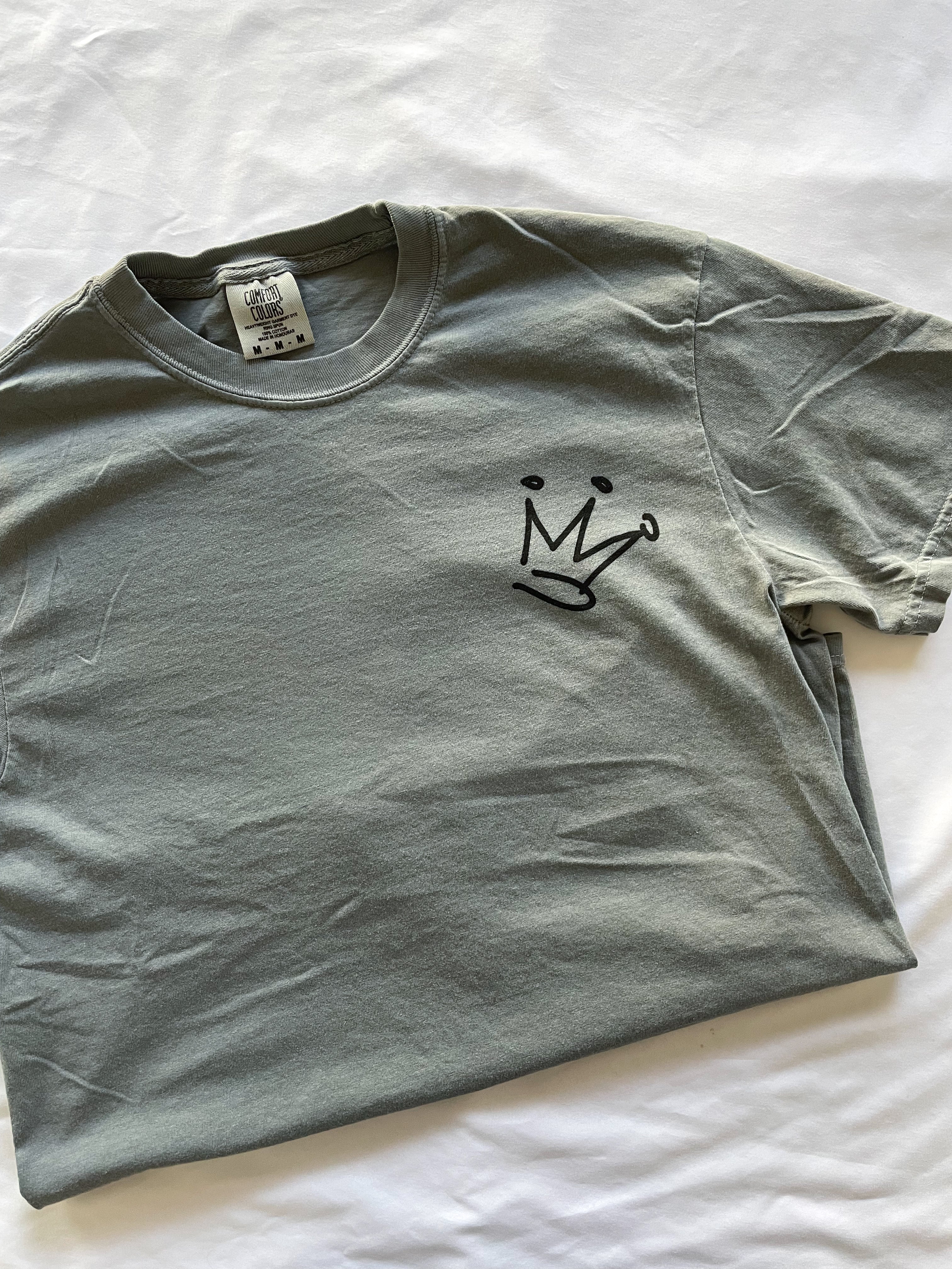a gray t - shirt with a black crown on it