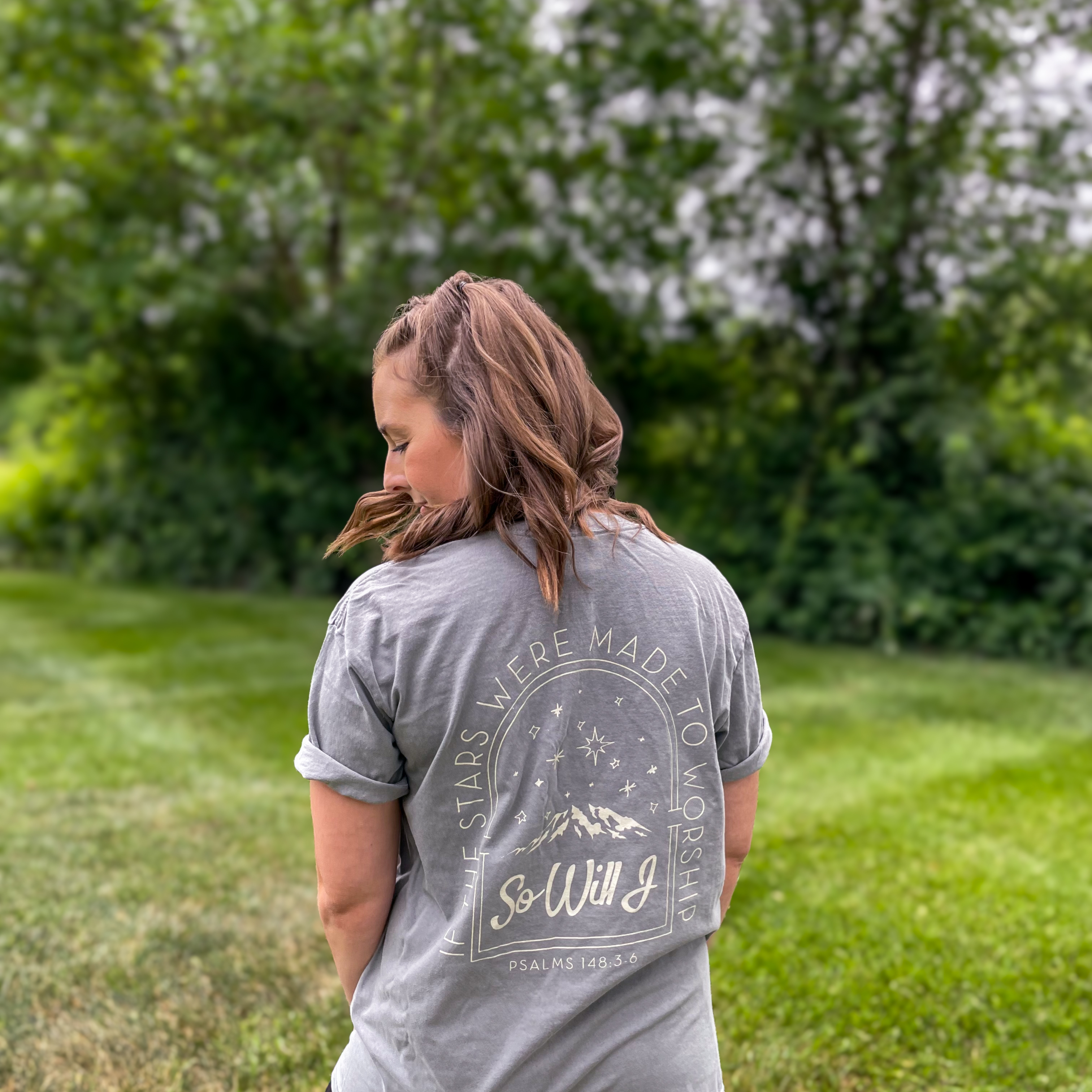 a woman standing in a field with her back to the camera