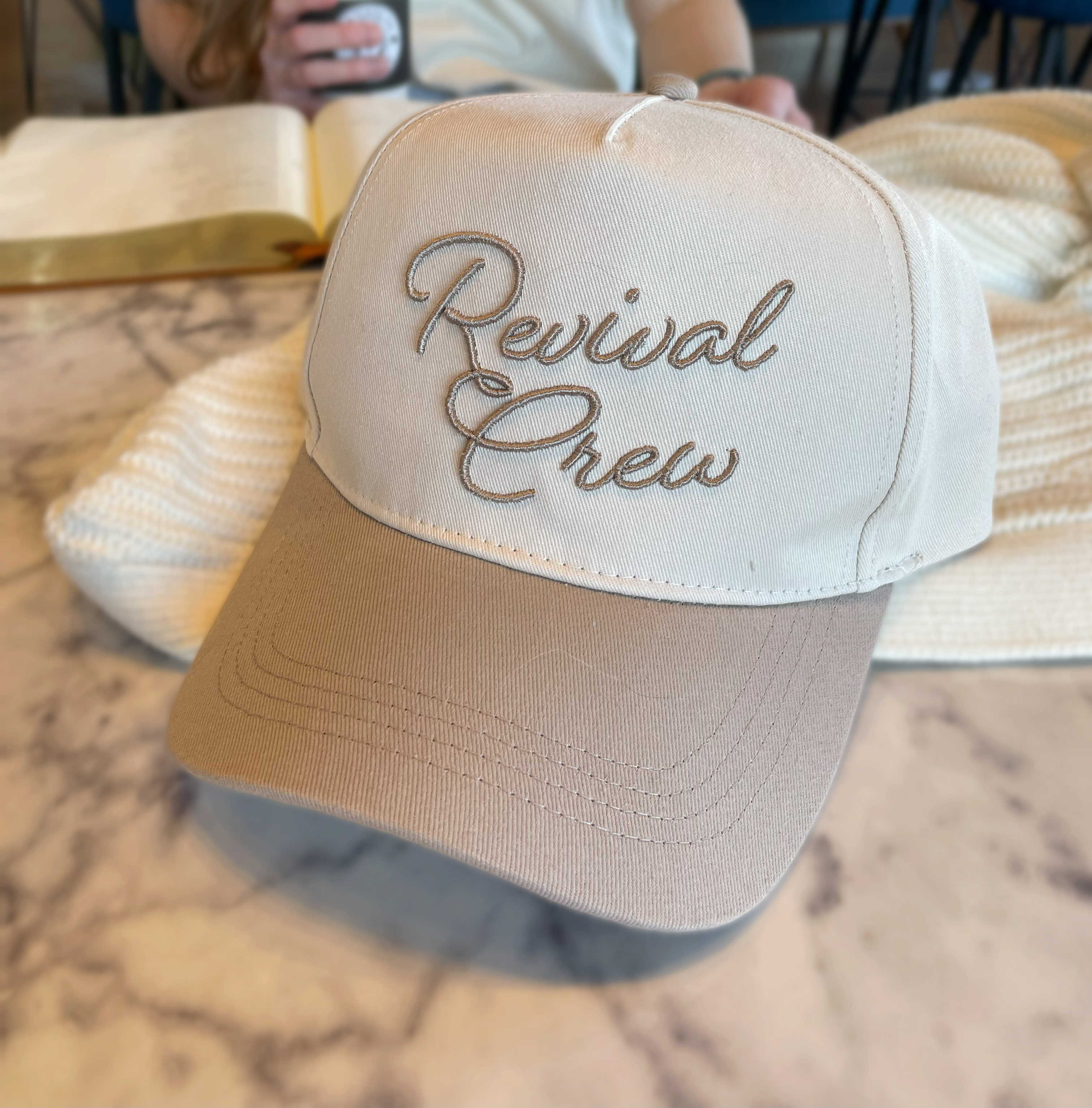 a person sitting at a table with a book and a hat