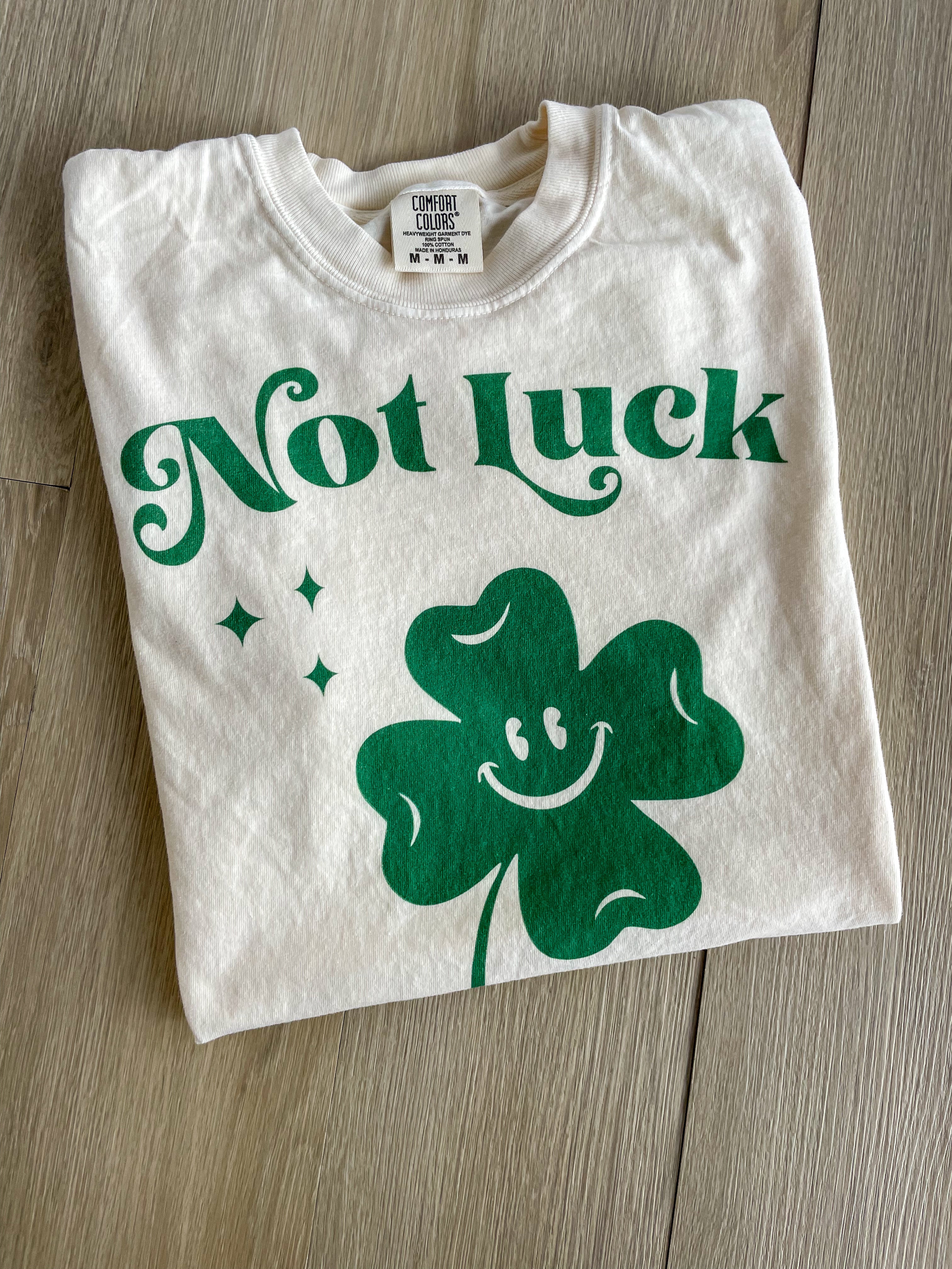 a white t - shirt with a green shamrock on it