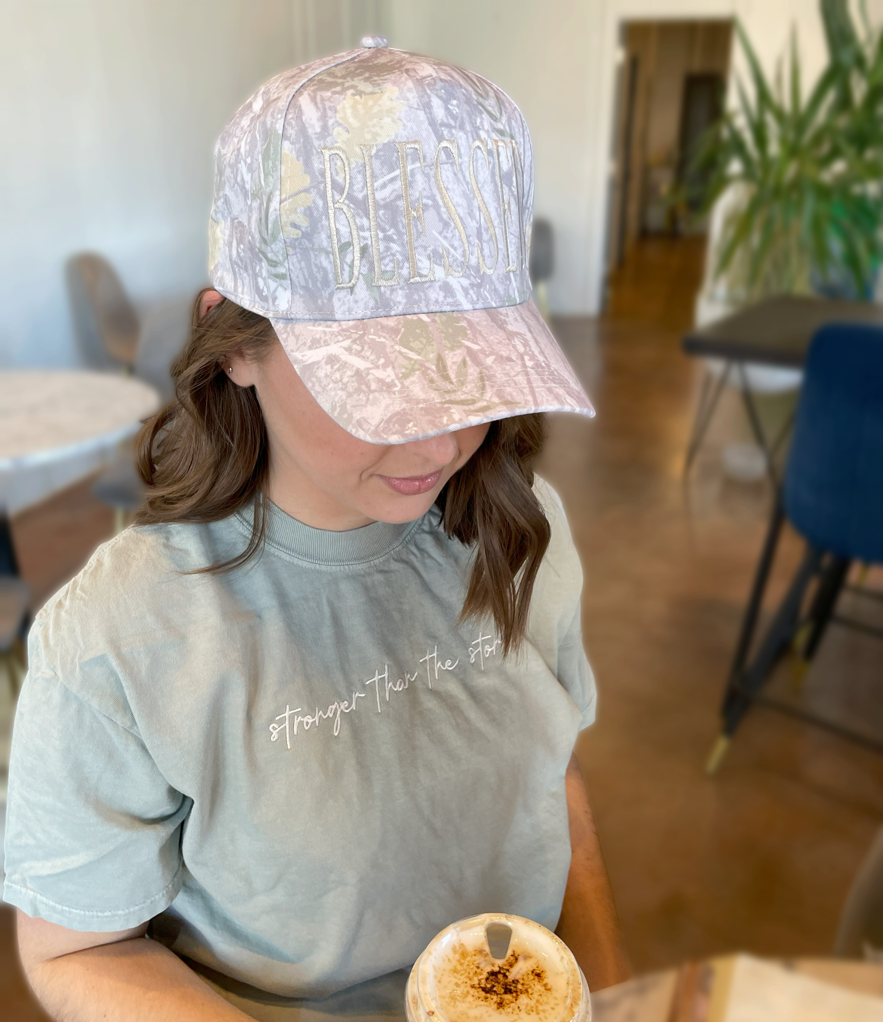 a woman wearing a hat holding a cup of coffee