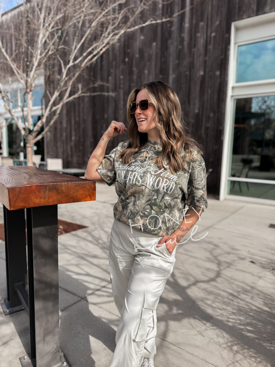 a woman standing next to a wooden table