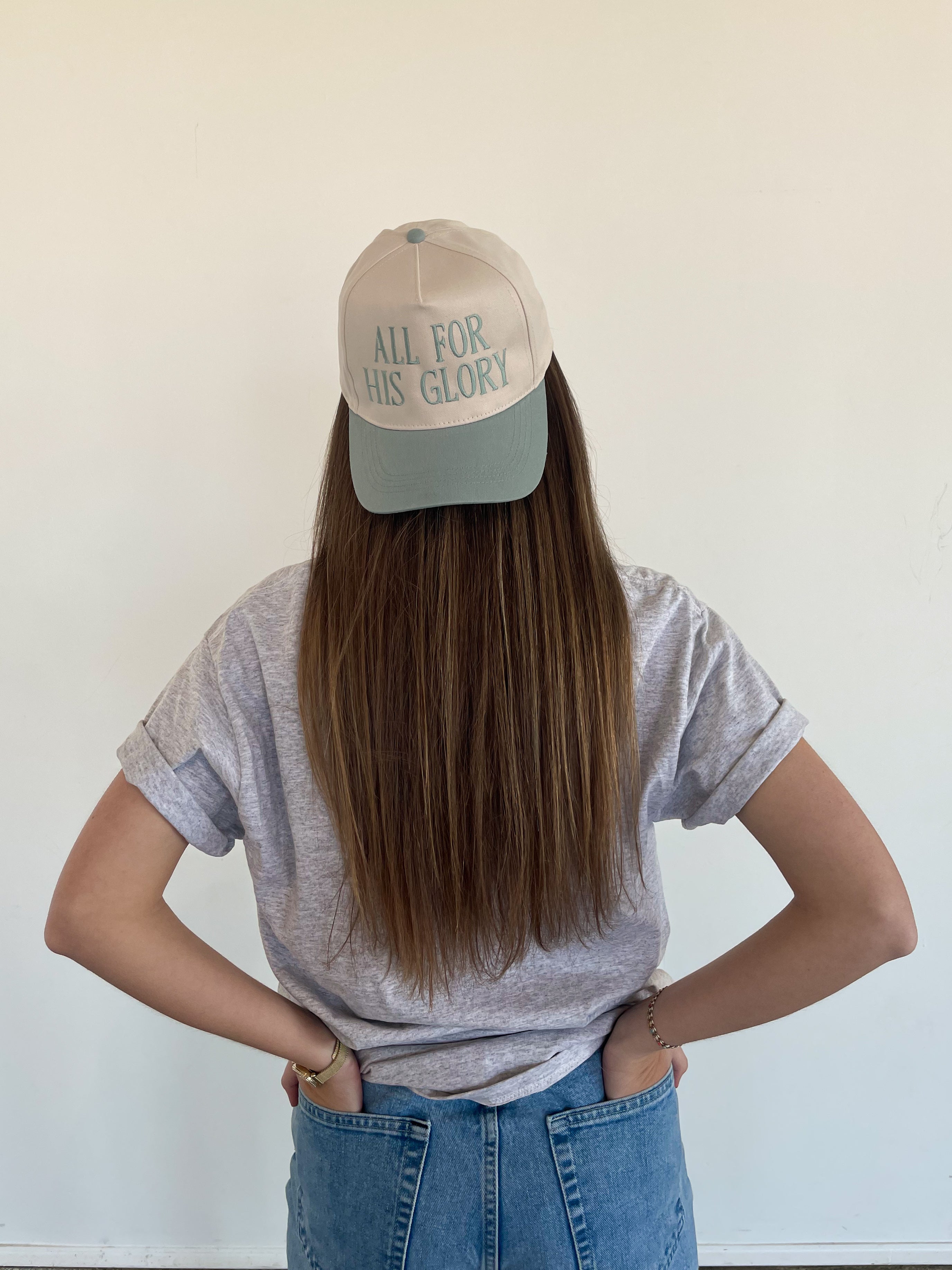 a woman wearing a hat that says all for his glory