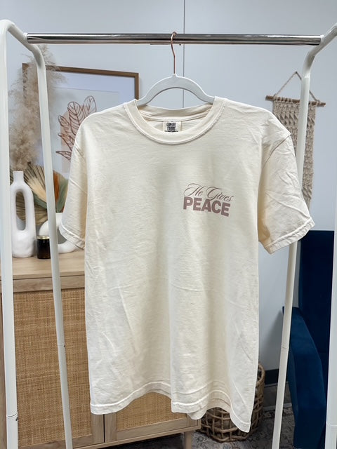a white t - shirt hanging on a clothes rack