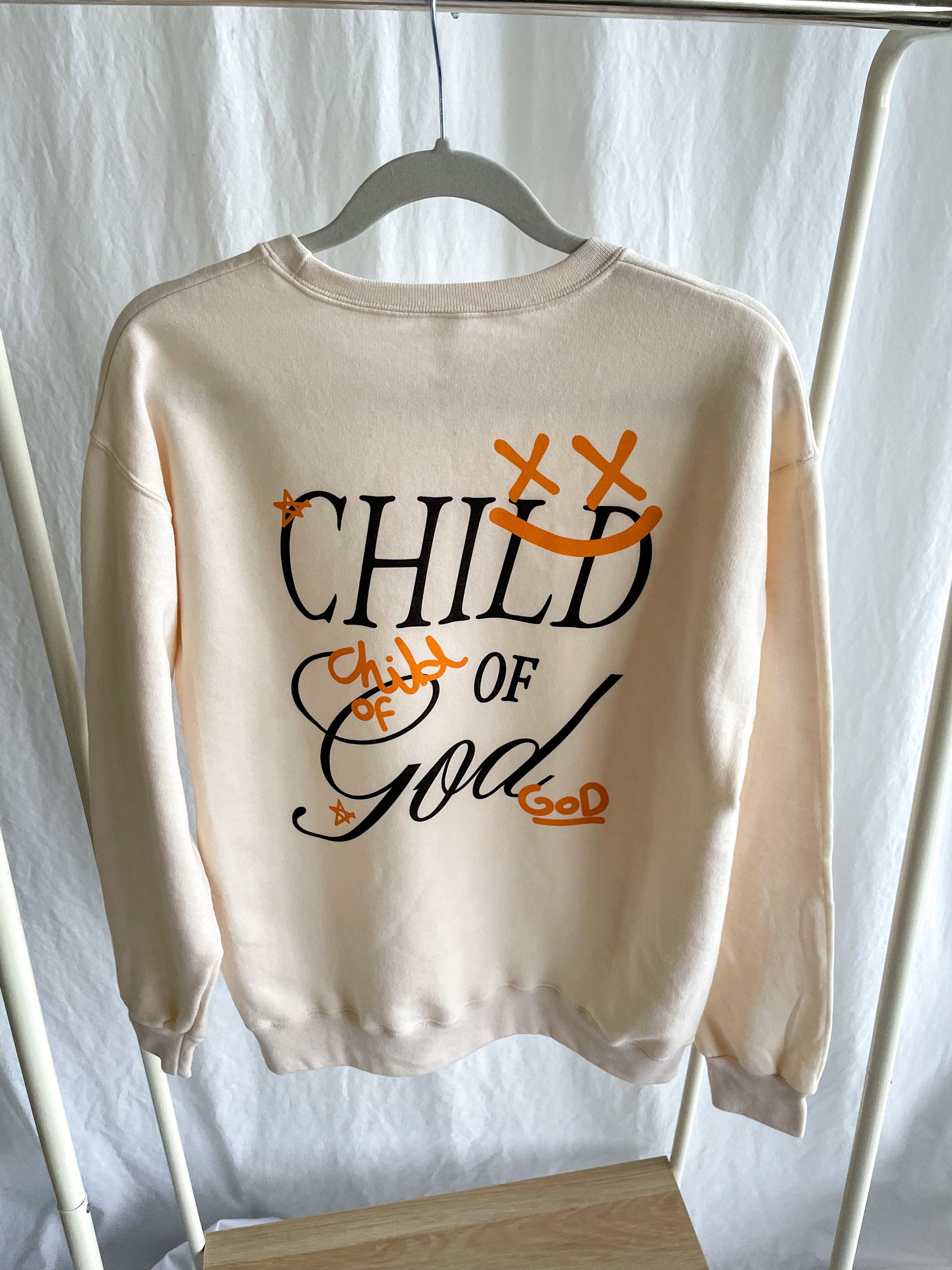 a child of god sweatshirt hanging on a clothes rack